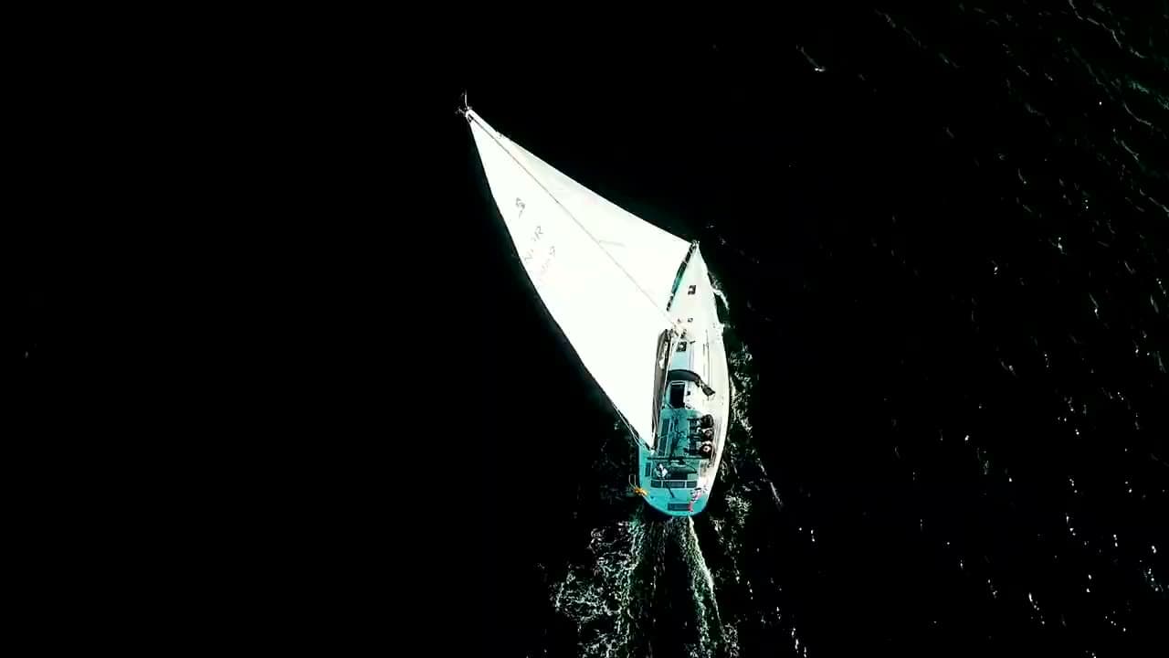 Film fra Sail On: en seilbåt fra luften på mørkt vann, to seilbåter forbi en solbelyst holme, og RIB-turer med gjester, til slutt i solnedgang